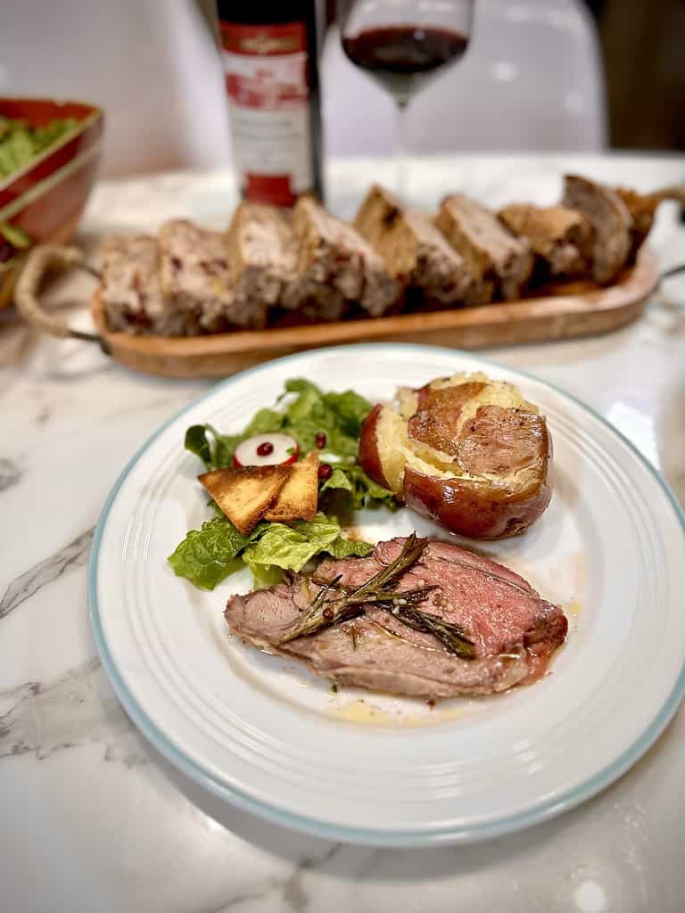 Plate of mediterranean lamb with baked potatoes and fattoush salad