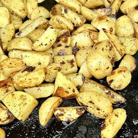 Delicious potatoes with greek style marinade being prepared on the griddle
