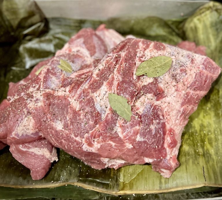 Preparing cochinita pibil before pouring in the marinade