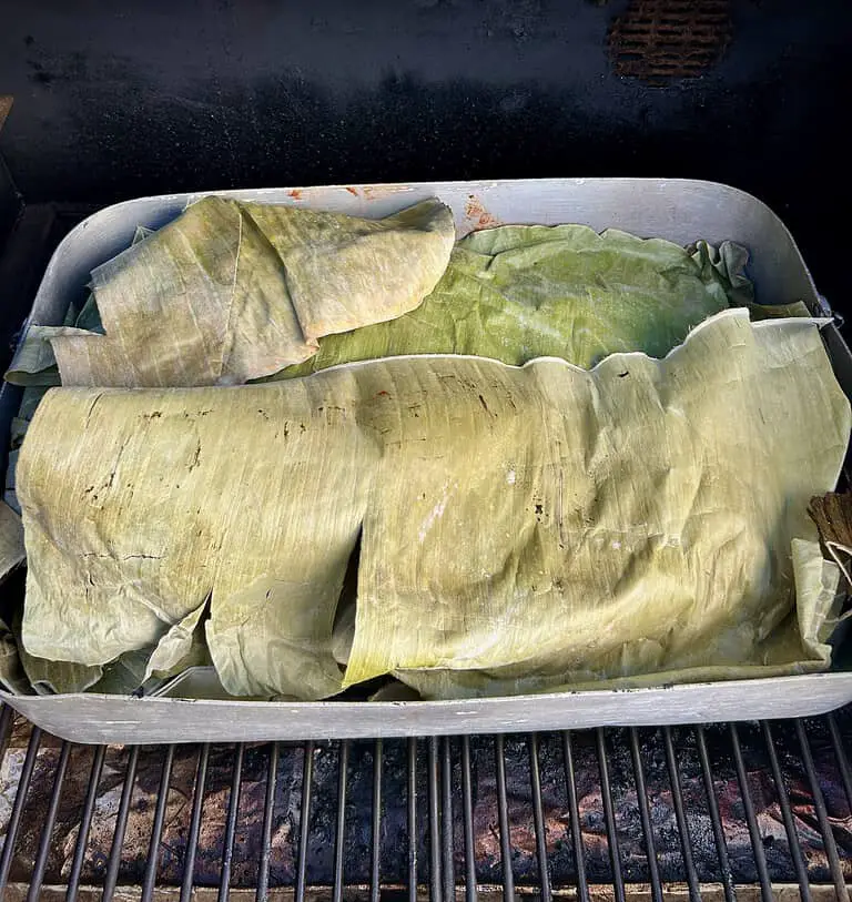 Cochinita pibil covered in banana leaves in the pellet smoker