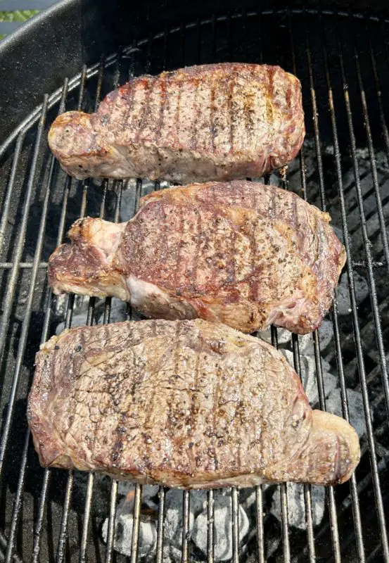 dry-aged rib eye steak on the grill almost ready to eat