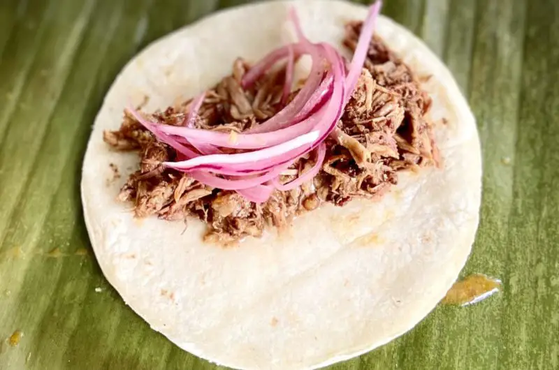 Cochinita pibil tacos served with pickled onions