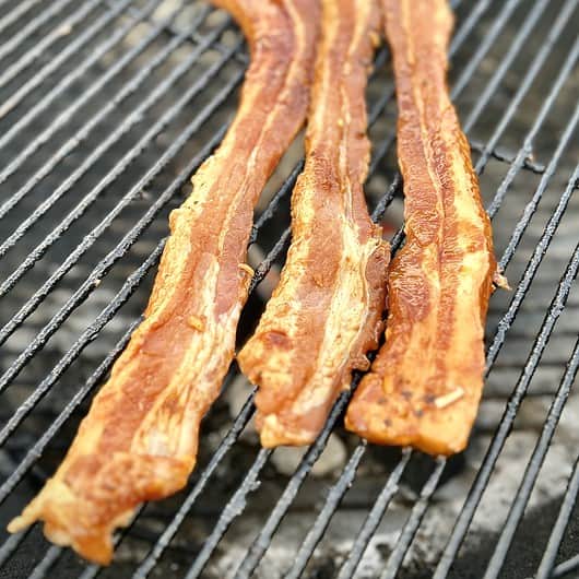 Deliciously hot and sweey marinade pork belly just placed on the grill for cooking