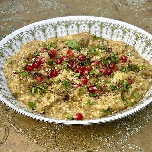 Smoky eggplant puree served with parsley, mint, and pomegranate